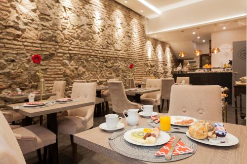 a restaurant with tables and chairs with food on them at Hotel Palacete de Alamos in Málaga