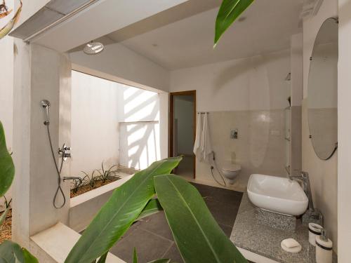 uma casa de banho com um WC, um chuveiro e um lavatório. em Kadal The Beach House em Pondicherry