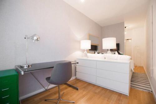 a bathroom with a sink and a desk with a chair at Hella Apartment in Zagreb