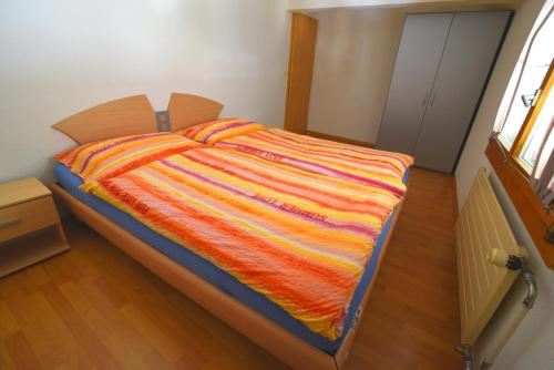 ein Bett mit einer bunten Decke auf einem Zimmer in der Unterkunft The River Holiday Apartment in Interlaken