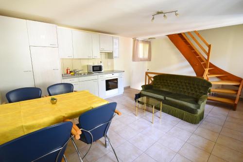 ein Wohnzimmer mit einem grünen Sofa und einem Tisch in der Unterkunft The River Holiday Apartment in Interlaken