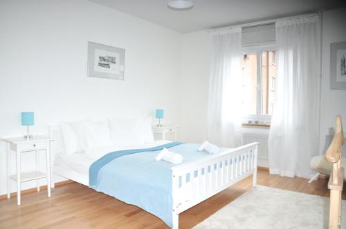 um quarto branco com uma cama branca e uma janela em Cozy Apartment Ulmenstrasse em Lucerna