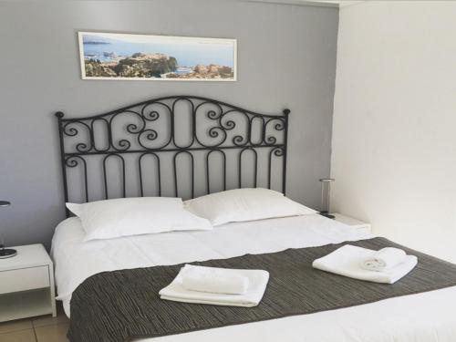 a bedroom with a bed with two white towels on it at Hotel Danemark in Nice