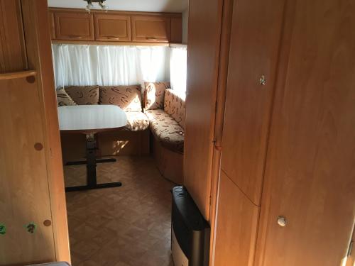 a small room with a couch and a chair in an rv at Przyczepy Kemping Polaris Półwysep Helski in Chałupy