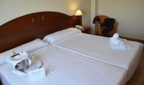 a hotel room with a bed with towels on it at Hotel Reyes Ziries in Albolote