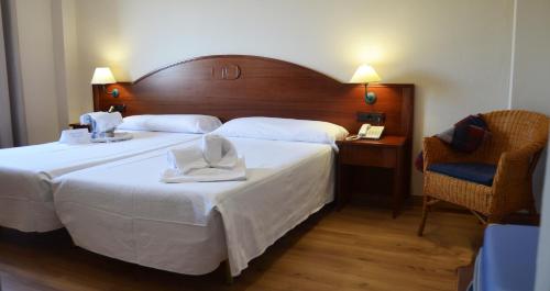 a hotel room with a bed with two towels on it at Hotel Reyes Ziries in Albolote