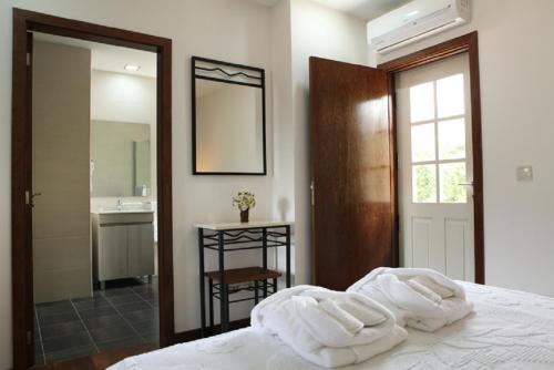 a bedroom with a bed with white towels on it at Recantos na Portela in Amares