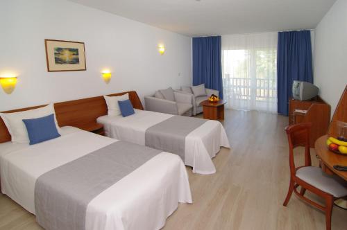 a hotel room with two beds and a couch at Bella Vista Beach Club - All Inclusive in Sinemorets