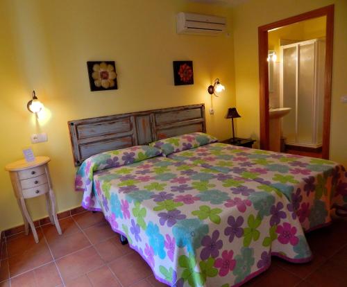 Casa Rural La Perra Gorda في Zorita: غرفة نوم مع سرير مع لحاف متهالك