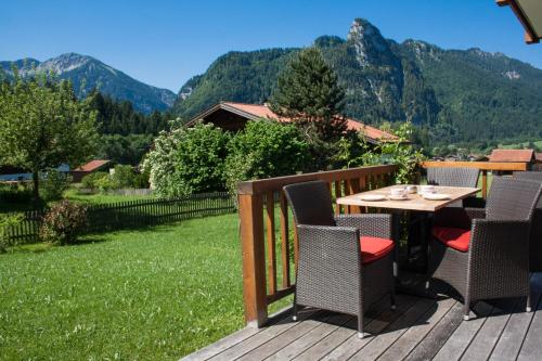 a deck with a table and chairs with mountains in the background at Ferienhaus Alpinissimo in Oberammergau