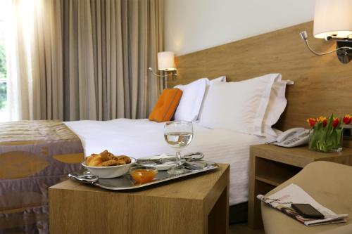 a hotel room with a tray of food on a bed at Golden Age Athens Hotel in Athens