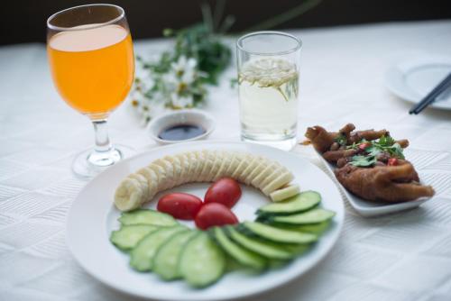 a table with a plate of food and a glass of beer at Yinfeng Hotel Guangzhou North Station Branch, Huacheng Road Subway Station Branch in Huadu