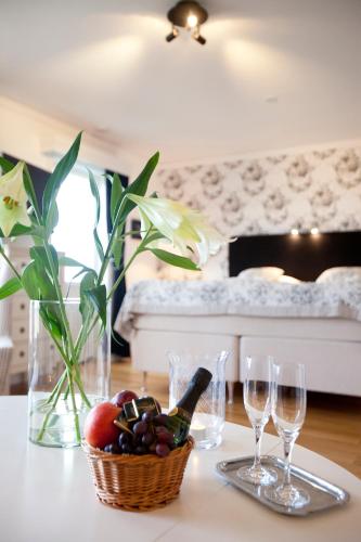 a table with wine glasses and a basket of fruit at Tällbergsgårdens Hotell in Tällberg