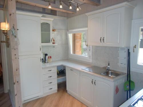 a kitchen with white cabinets and a sink at Casa Carla in Ledro