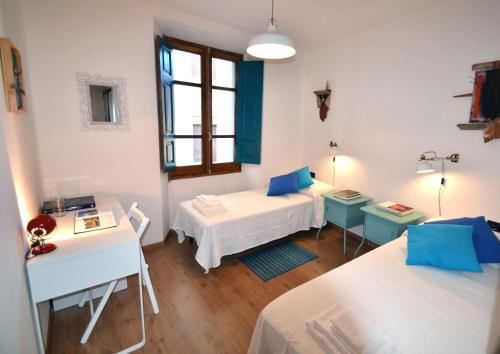 Cette chambre comprend deux lits, un bureau et une fenêtre. dans l'établissement Il Bandito Re, à Nuoro
