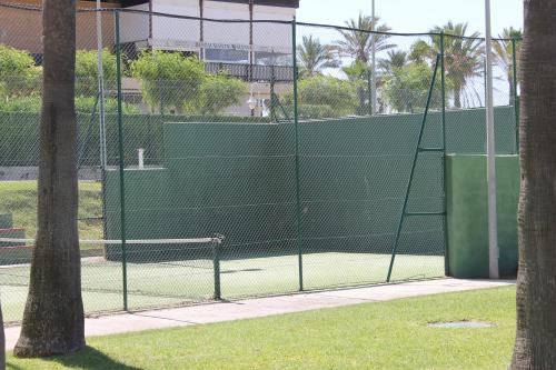a tennis court with a net on a tennis court at atico en Las Americas Islantilla primera línea de playa in Islantilla
