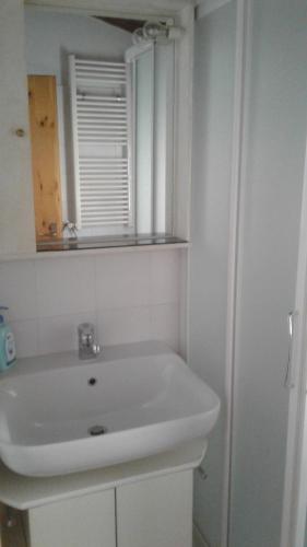 ソーリコにあるHoliday home Désiréeの白いバスルーム(シンク、鏡付)