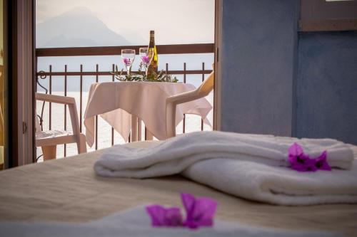 a bed with a towel and two glasses of wine at Taki Village in Brenzone sul Garda