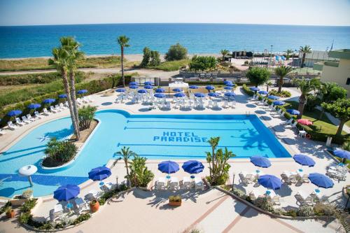 - une vue aérienne sur un hôtel paradisiaque avec une piscine et l'océan dans l'établissement Hotel Village Paradise, à Mandatoriccio Marina
