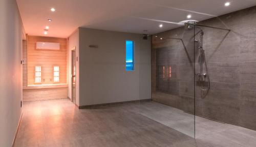 y baño con ducha y ventana azul. en Villa 121, en Berlare
