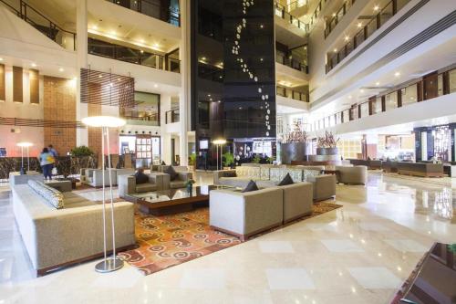 a lobby with couches and tables in a building at Clarion Bella Casa at Airport in Jaipur