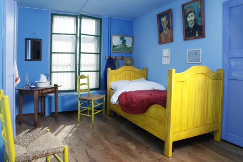 Schlafzimmer mit gelbem Bett und blauen Wänden in der Unterkunft Hotel Restaurant Riche in Boxmeer