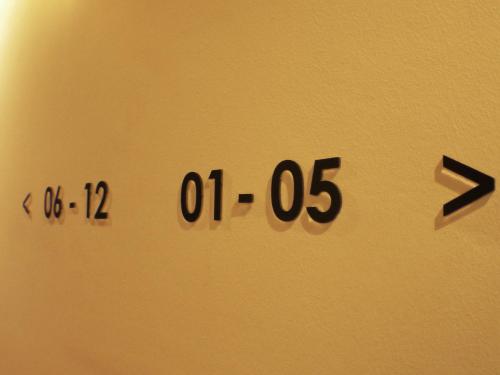 a wall with a clock on the side of it at Hako Hotel in Skudai