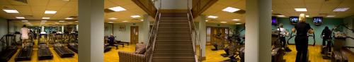 a gym with a staircase and people exercising on bikes at Best Western Frodsham Forest Hills Hotel in Frodsham