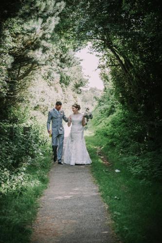 a bride and groom walking down a path at Best Western Frodsham Forest Hills Hotel in Frodsham