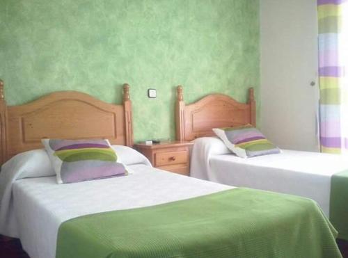 1 dormitorio con 2 camas de color verde y púrpura en Bar Posada Bemi, en Almorox