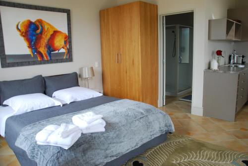 a bedroom with a bed with two towels on it at Windhover Suites in Tasman