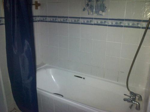 a white bath tub with a black shower curtain at Durban Accommodation 118 Summersands in Durban