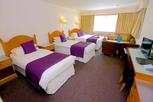 a hotel room with two beds and a television at Best Western Frodsham Forest Hills Hotel in Frodsham