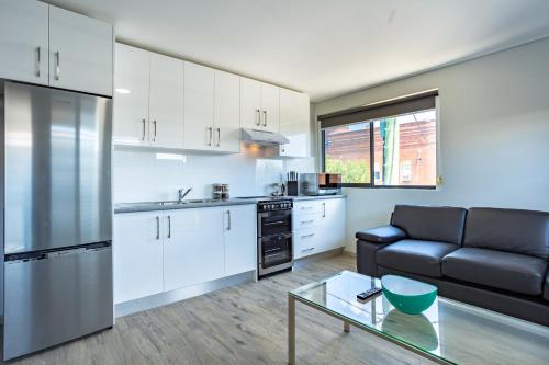 a kitchen and living room with a couch and a table at Hamilton on Beaumont in Newcastle