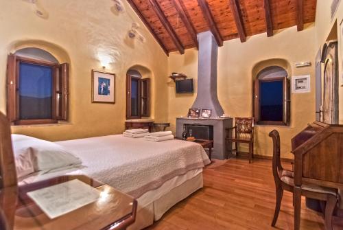 a bedroom with a large bed and a fireplace at Petropoulakis Tower in Gythio