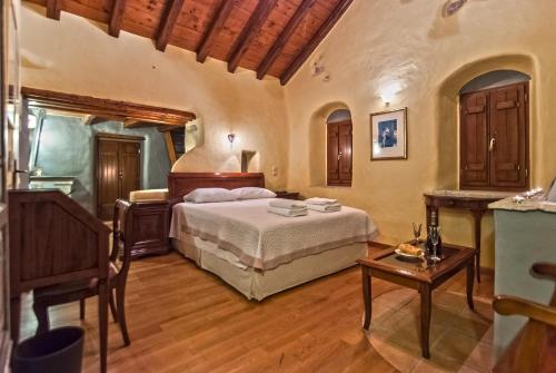 a bedroom with a bed and a table at Petropoulakis Tower in Gythio