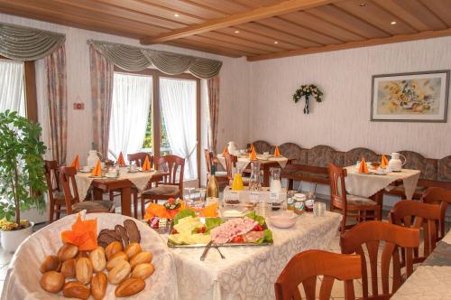 ein Restaurant mit Tischen und Stühlen mit Essen darauf in der Unterkunft Gästehaus Hanewald in Bad Dürkheim