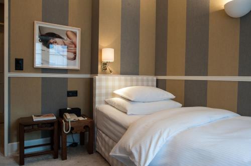a hotel room with a bed and a picture on the wall at Hotel Kindli in Zurich