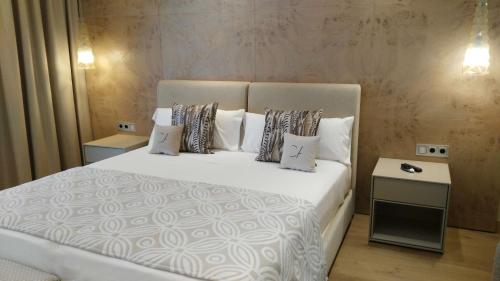 1 dormitorio con 1 cama blanca grande con almohadas en Cosmo Apartments Platja d'Aro, en Platja d'Aro