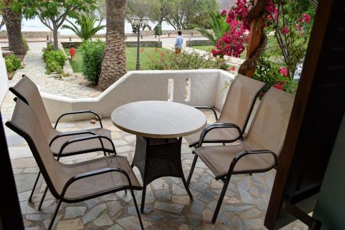 a patio with a table and chairs on a patio at Grandes Apartments sea front in Palekastron