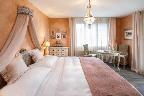 a bedroom with a large bed and a table at Hotel & Restaurant zum Beck in Stansstad