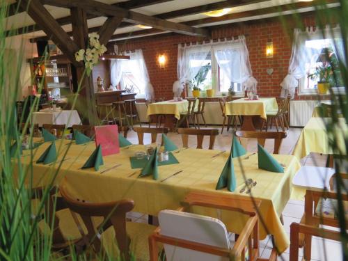 a dining room with tables and chairs with yellow table cloth at Uschi's Gasthof in Neuendorf