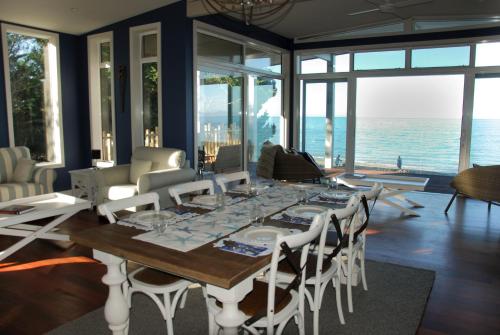 a dining room with a table and chairs and the ocean at Windhover Suites in Tasman
