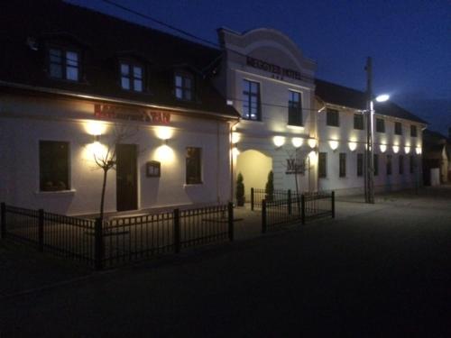 a large white building with lights on it at night at Meggyes Hotel in Szerencs