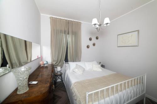 a white bedroom with a bed and a window at Les Petites Maisons in Marta