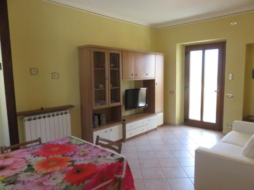 a living room with a bed and a television at La Palma in Domodossola