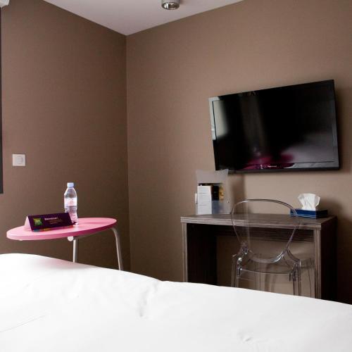 a bedroom with a bed and a table and a tv at ibis Styles Rennes St. Gregoire in Saint-Grégoire