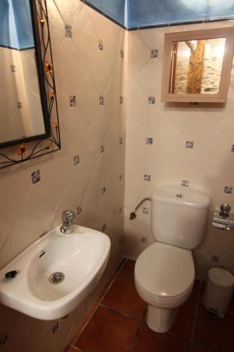 uma casa de banho com um WC branco e um lavatório. em Can Mariano em Mollet de Perelada