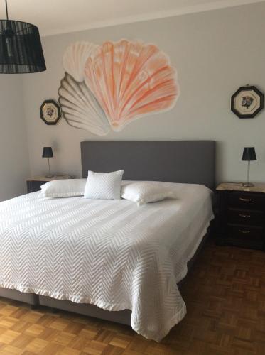a bedroom with a bed with a shell on the wall at Guest House A&z in Espinho