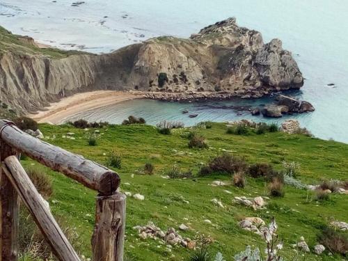 a view of a beach with a wooden fence at La Collina sul Mare in Palma di Montechiaro
